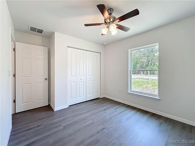 22777 SW Beach Blvd, Dunnellon, FL 34431 - unfurnished bedroom with dark wood-type flooring, baseboards, a closet, and ceiling fan