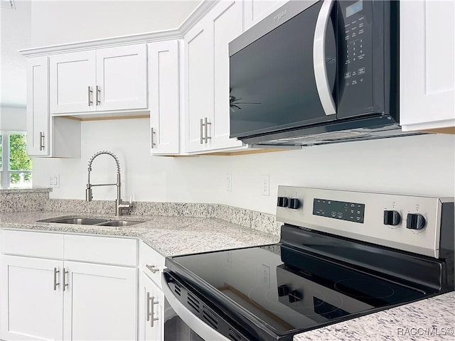 22777 SW Beach Blvd, Dunnellon, FL 34431 - kitchen featuring stainless steel range with electric cooktop, a sink, white cabinets, and light stone countertops