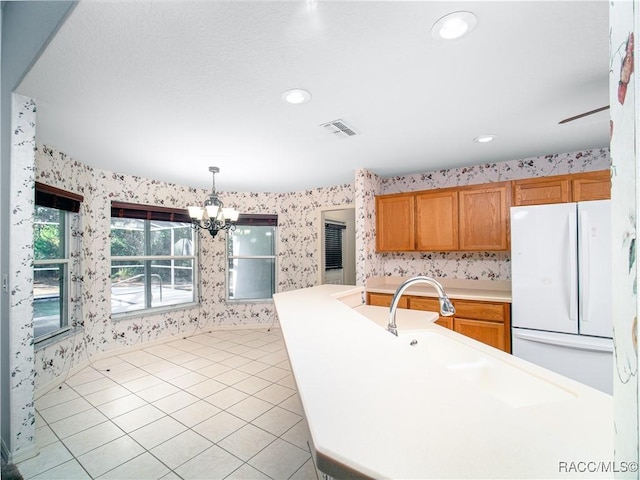 kitchen featuring hanging light fixtures, a notable chandelier, light tile patterned flooring, and white refrigerator