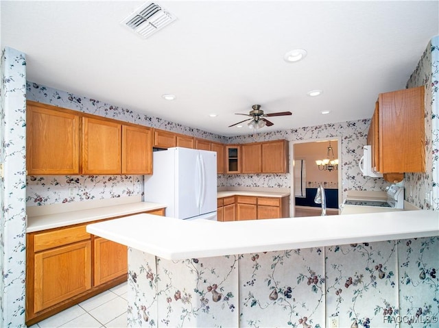 kitchen featuring a kitchen breakfast bar, light tile patterned floors, ceiling fan, kitchen peninsula, and white appliances