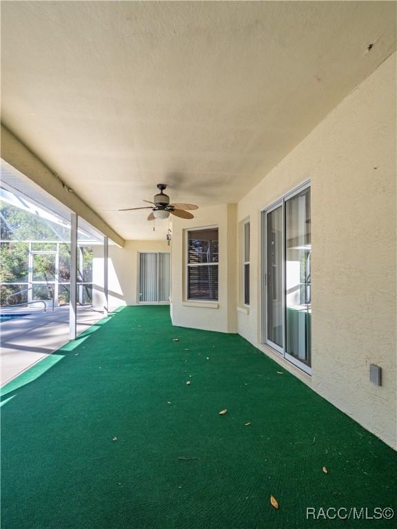 view of patio / terrace with ceiling fan and a lanai