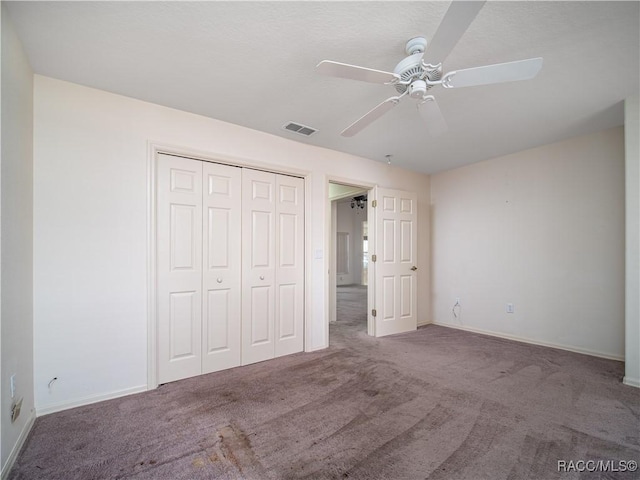 unfurnished bedroom with carpet floors, a closet, and ceiling fan