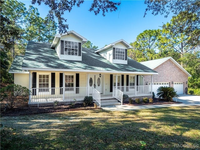 view of front of property featuring a porch, a garage, and a front lawn