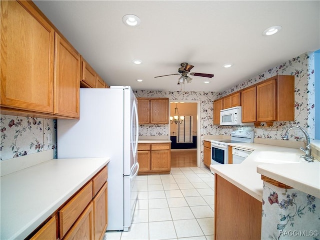 kitchen featuring ceiling fan with notable chandelier, sink, light tile patterned floors, and white appliances