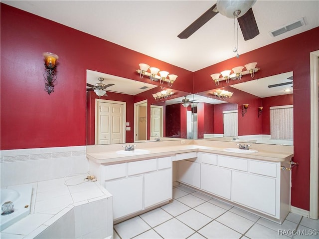 bathroom featuring vanity, a relaxing tiled tub, tile patterned floors, and ceiling fan