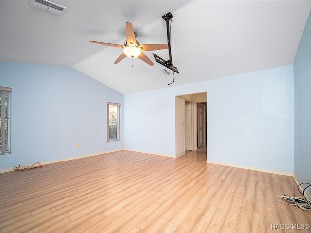 unfurnished living room with vaulted ceiling, a healthy amount of sunlight, ceiling fan, and light wood-type flooring