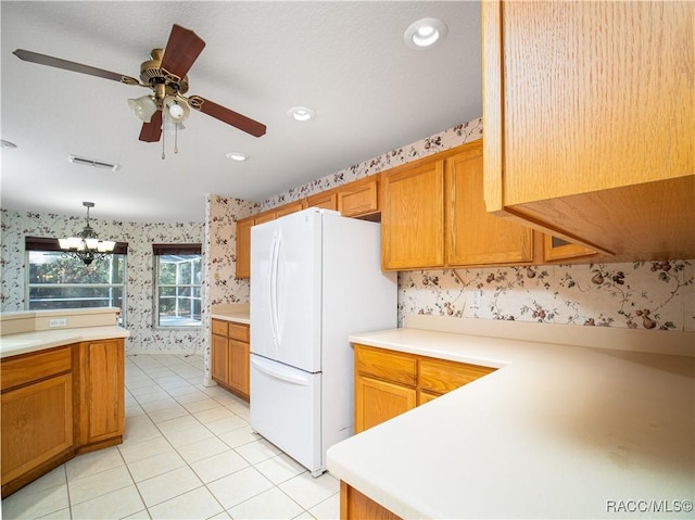 kitchen featuring light tile patterned flooring, decorative light fixtures, ceiling fan with notable chandelier, and white fridge