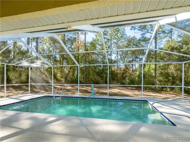 view of pool with a patio and glass enclosure