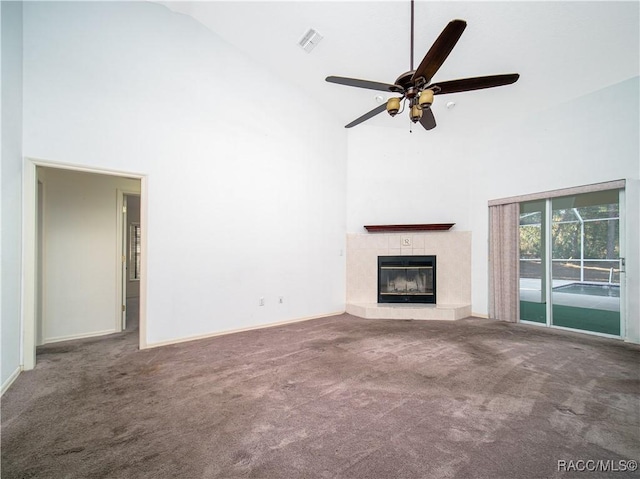 unfurnished living room with ceiling fan, carpet floors, high vaulted ceiling, and a tile fireplace