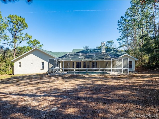 rear view of house with a patio and glass enclosure