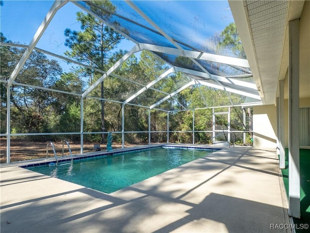 view of swimming pool featuring a patio and glass enclosure