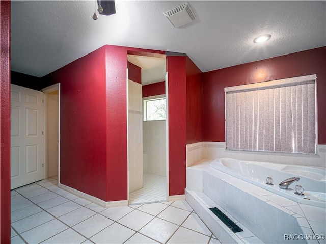 bathroom featuring tile patterned flooring, plus walk in shower, and a textured ceiling