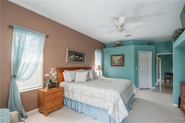 bedroom with light carpet, a closet, multiple windows, and ceiling fan