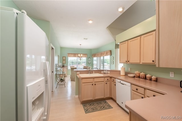 kitchen with sink, light hardwood / wood-style flooring, kitchen peninsula, decorative light fixtures, and white appliances