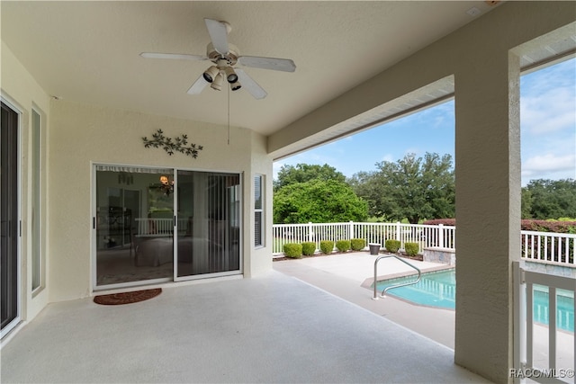 view of swimming pool featuring ceiling fan and a patio area