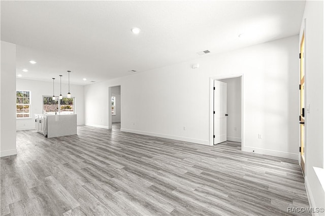 unfurnished living room featuring light wood-type flooring, baseboards, visible vents, and recessed lighting