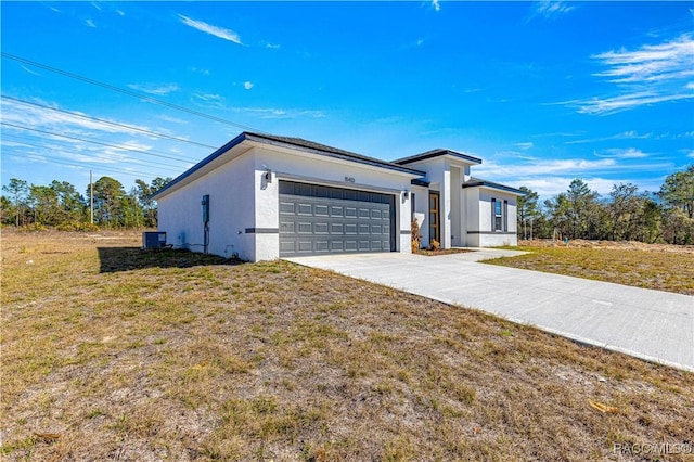 view of front of house featuring central air condition unit, stucco siding, concrete driveway, a garage, and a front lawn