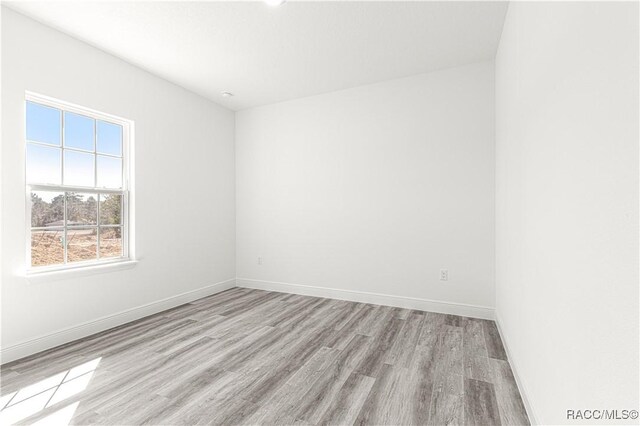 unfurnished room featuring light wood-style flooring and baseboards