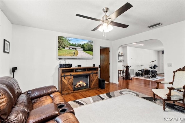 1420 E Silver Thorn Loop, Hernando, FL 34442 - living area with arched walkways, wood finished floors, a ceiling fan, and a glass covered fireplace