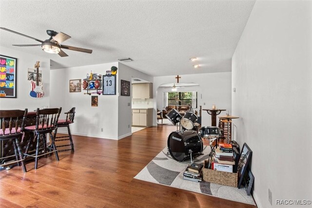 1420 E Silver Thorn Loop, Hernando, FL 34442 - living room featuring ceiling fan, wood finished floors, a textured ceiling, a dry bar, and baseboards