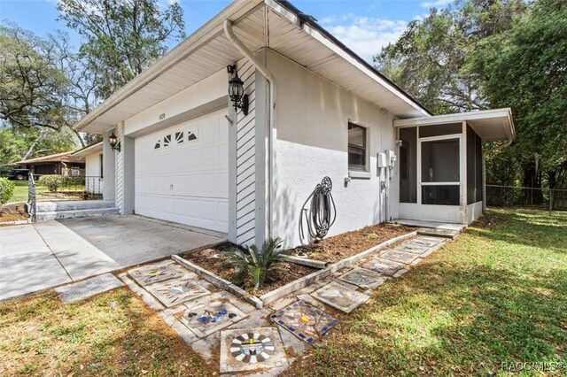 1420 E Silver Thorn Loop, Hernando, FL 34442 - view of side of home with a sunroom, stucco siding, a garage, and concrete driveway