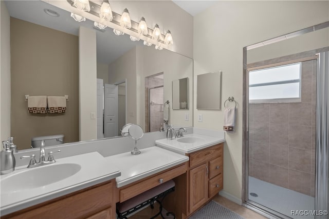 bathroom with tile patterned floors, vanity, toilet, and a shower with shower door