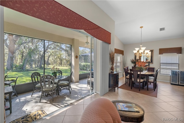 interior space with vaulted ceiling, light tile patterned floors, and a notable chandelier