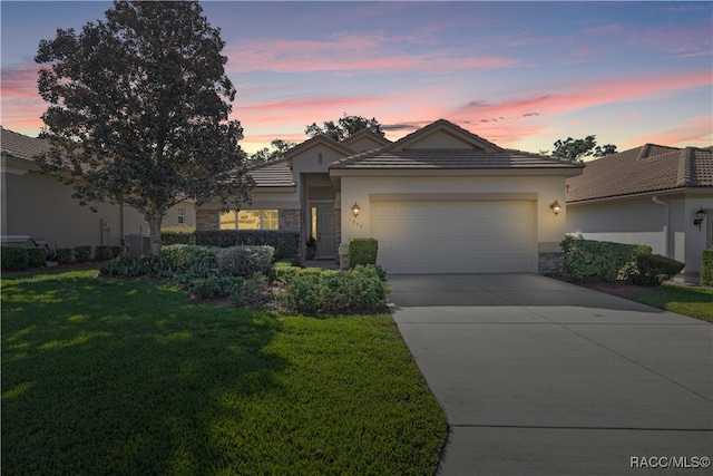 view of front of property with a garage and a yard