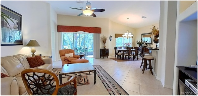 tiled living room featuring ceiling fan with notable chandelier and vaulted ceiling