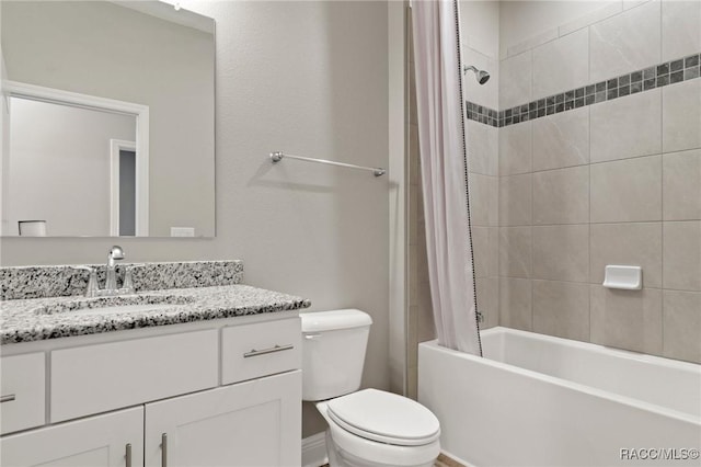 full bathroom with vanity, tiled shower / bath combo, and toilet