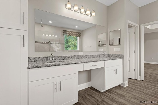 bathroom with a shower, hardwood / wood-style floors, and vanity