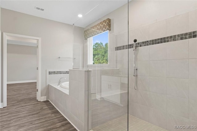 bathroom featuring hardwood / wood-style floors and plus walk in shower