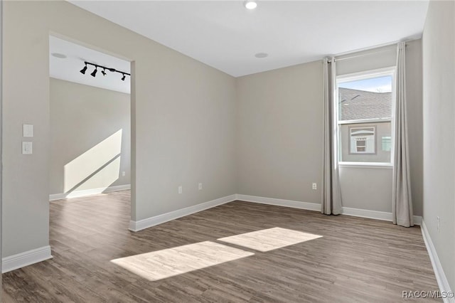 unfurnished room with hardwood / wood-style floors and track lighting