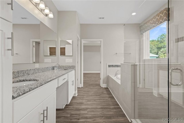 bathroom featuring hardwood / wood-style floors, vanity, and separate shower and tub