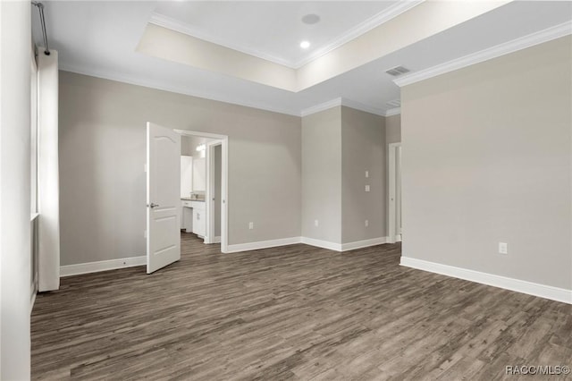 unfurnished bedroom with dark hardwood / wood-style floors, a raised ceiling, crown molding, and ensuite bath