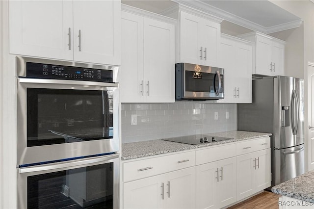 kitchen featuring light stone countertops, white cabinets, light hardwood / wood-style floors, and appliances with stainless steel finishes