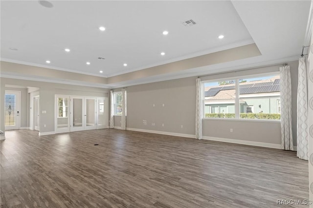 unfurnished living room with crown molding, plenty of natural light, and wood-type flooring