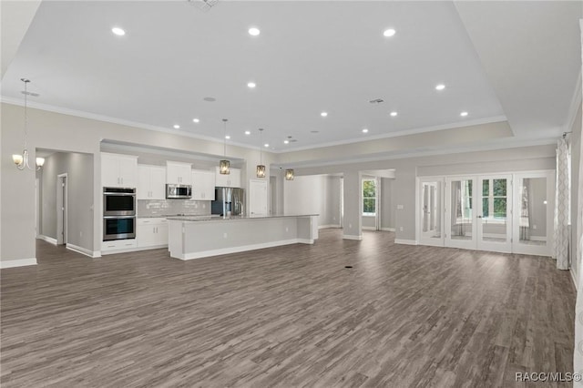 unfurnished living room with dark hardwood / wood-style floors, ornamental molding, and a chandelier