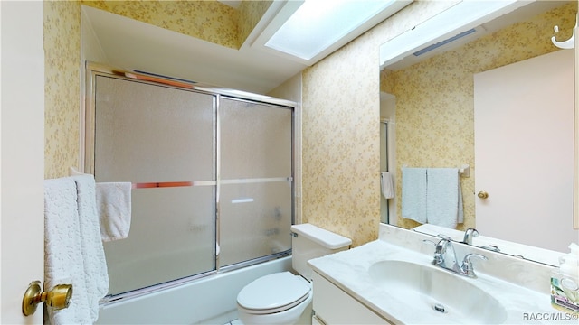 full bathroom with vanity, toilet, and shower / bath combination with glass door