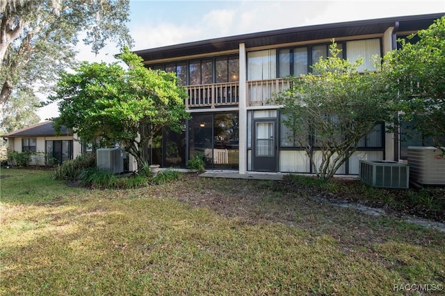 back of property with a yard and central AC unit