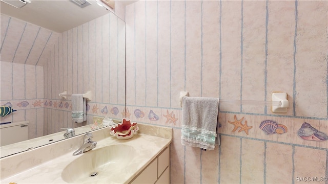 bathroom featuring vanity and tile walls