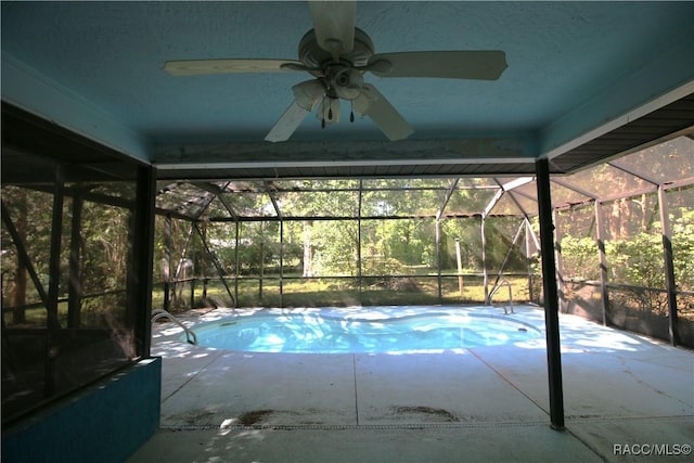 outdoor pool with a lanai, a patio area, and a ceiling fan