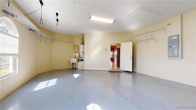 garage featuring sink, electric panel, and gas water heater