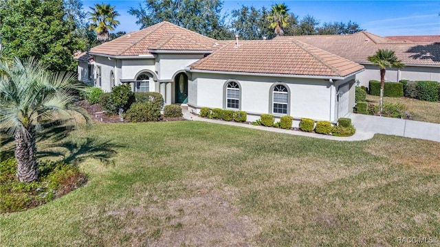 mediterranean / spanish home with a front yard