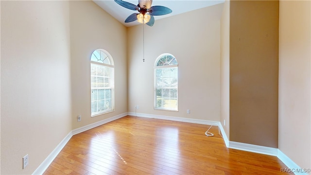 unfurnished room with ceiling fan, high vaulted ceiling, and light hardwood / wood-style flooring