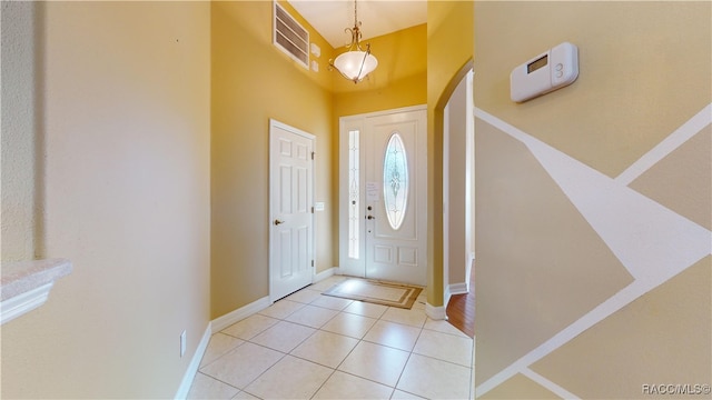 tiled foyer with a towering ceiling