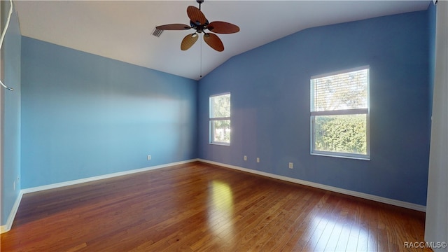 unfurnished room with ceiling fan, a wealth of natural light, hardwood / wood-style floors, and vaulted ceiling