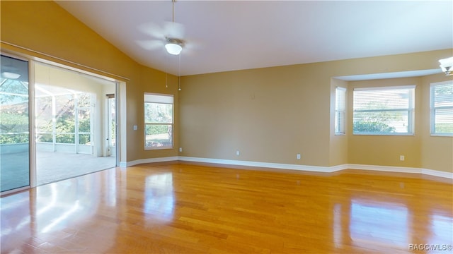 unfurnished room with light wood-type flooring, ceiling fan, vaulted ceiling, and plenty of natural light