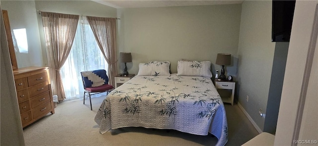 bedroom featuring light colored carpet and baseboards