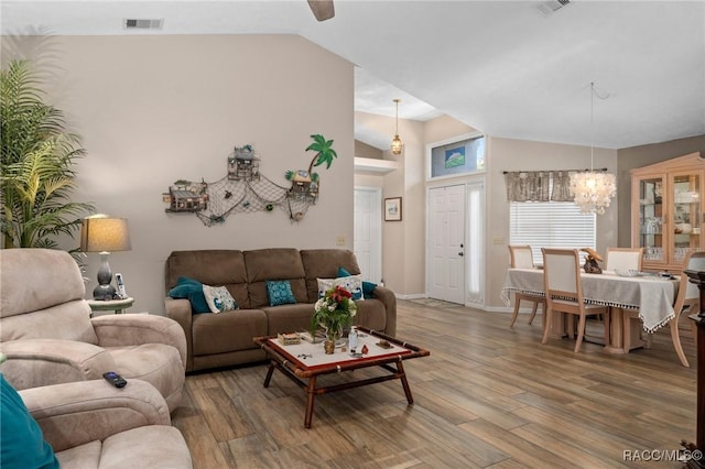 living room featuring visible vents, high vaulted ceiling, baseboards, and wood finished floors